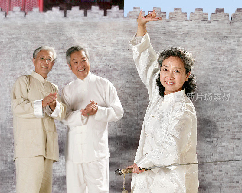 three oriental senior adults doing Taijiquan
